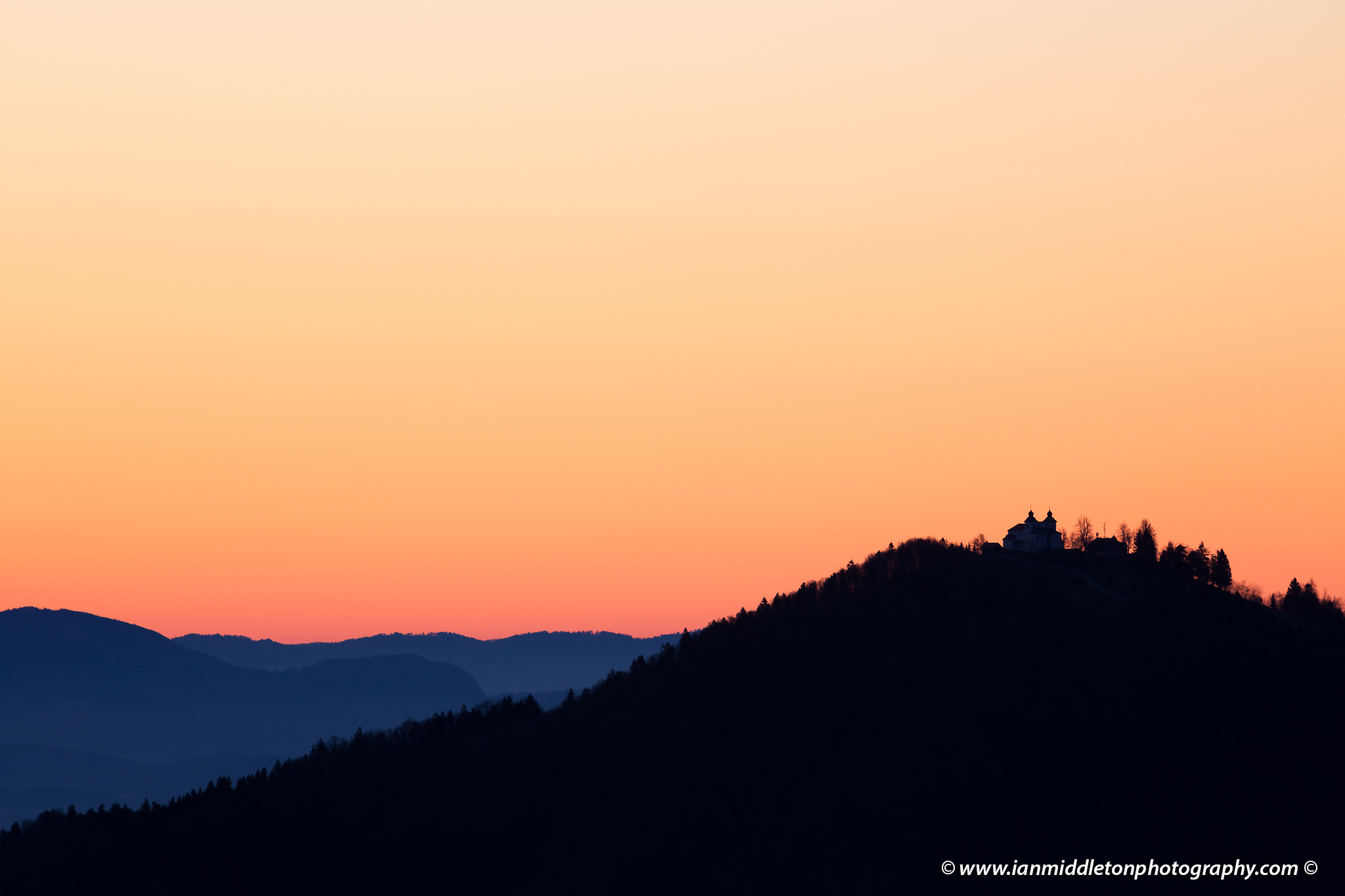 Sunrise view across to the church of Sv Jost above Kranj, Slovenia. Seen from Jamnik.