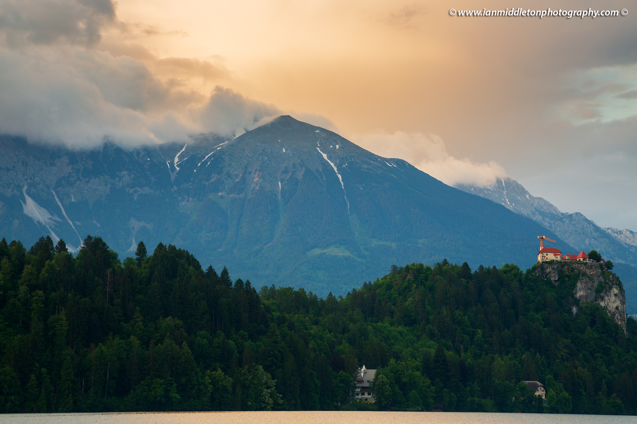 Beautiful light across the beautiful Lake Bled's hilltop castle and Mount Stol, the highest peak in the Karavank Mountains. Slovenia.