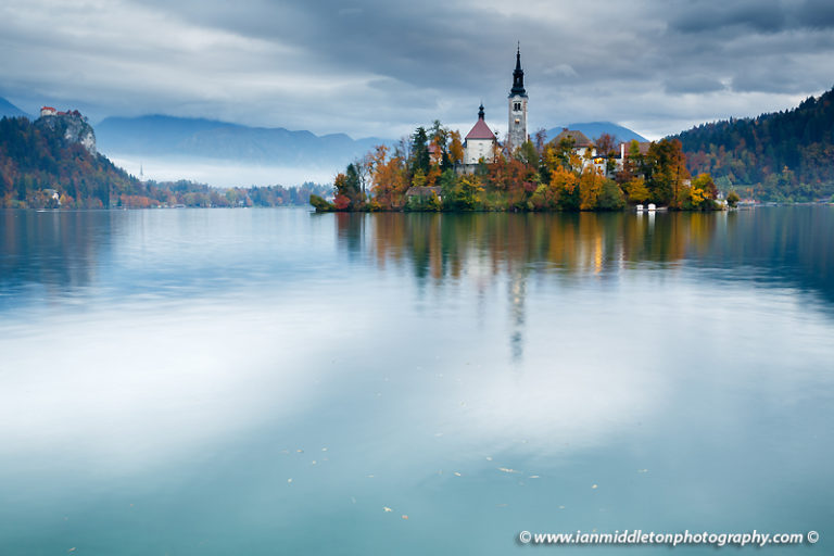 View across Lake Bled to the island church and clifftop castle in all it's autumn glory, Slovenia.