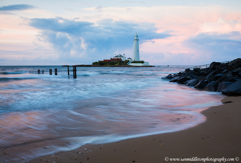 Saint Mary's Lighthouse on Saint Mary's Island, situated north of Whitley Bay, Tyne and Wear, North East England. Seen at sunset from the beach beside the causeway that runs out to the island. Whitley Bay is situated just north of Newcastle.