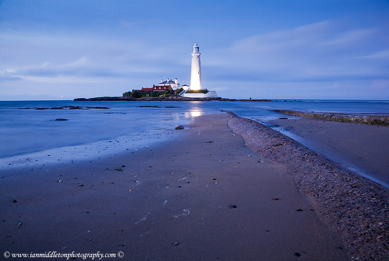 Saint Mary's Lighthouse on Saint Mary's Island, situated north of Whitley Bay, Tyne and Wear, North East England. Seen at dusk from the beach beside the causeway that runs out to the island. Whitley Bay is situated just north of Newcastle.