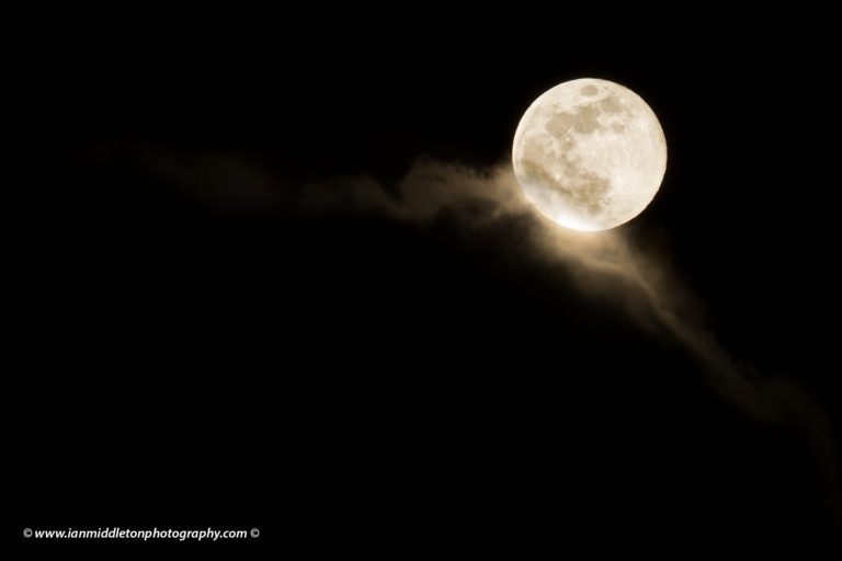 Easter blue moon of March 2018 rising out of the clouds after a rainstorm