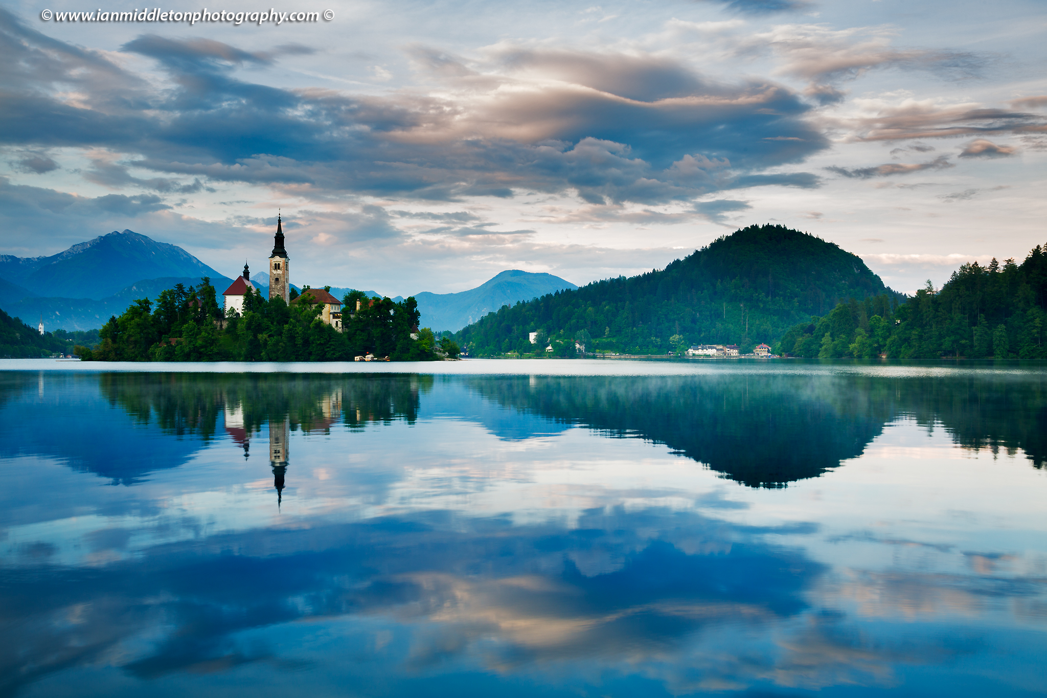 View across the beautiful Lake Bled, island church at sunset with the beautiful Karavank mountains in the background, Slovenia. Lake Bled is Slovenia's most popular tourist destination and the Karawanke mountains form the border between Slovenia and Austria.