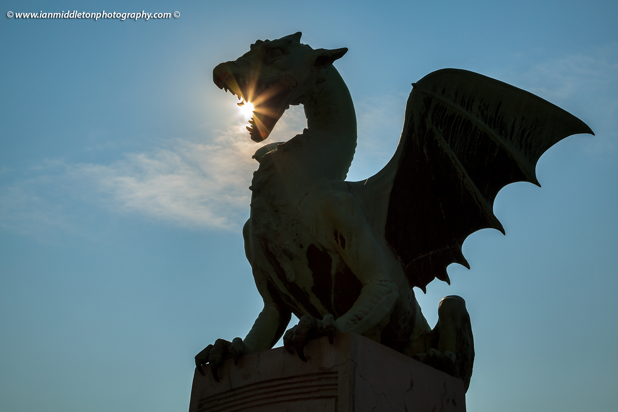 Sunburst through the mouth of a dragon on the Dragon Bridge in Ljubljana, Slovenia.