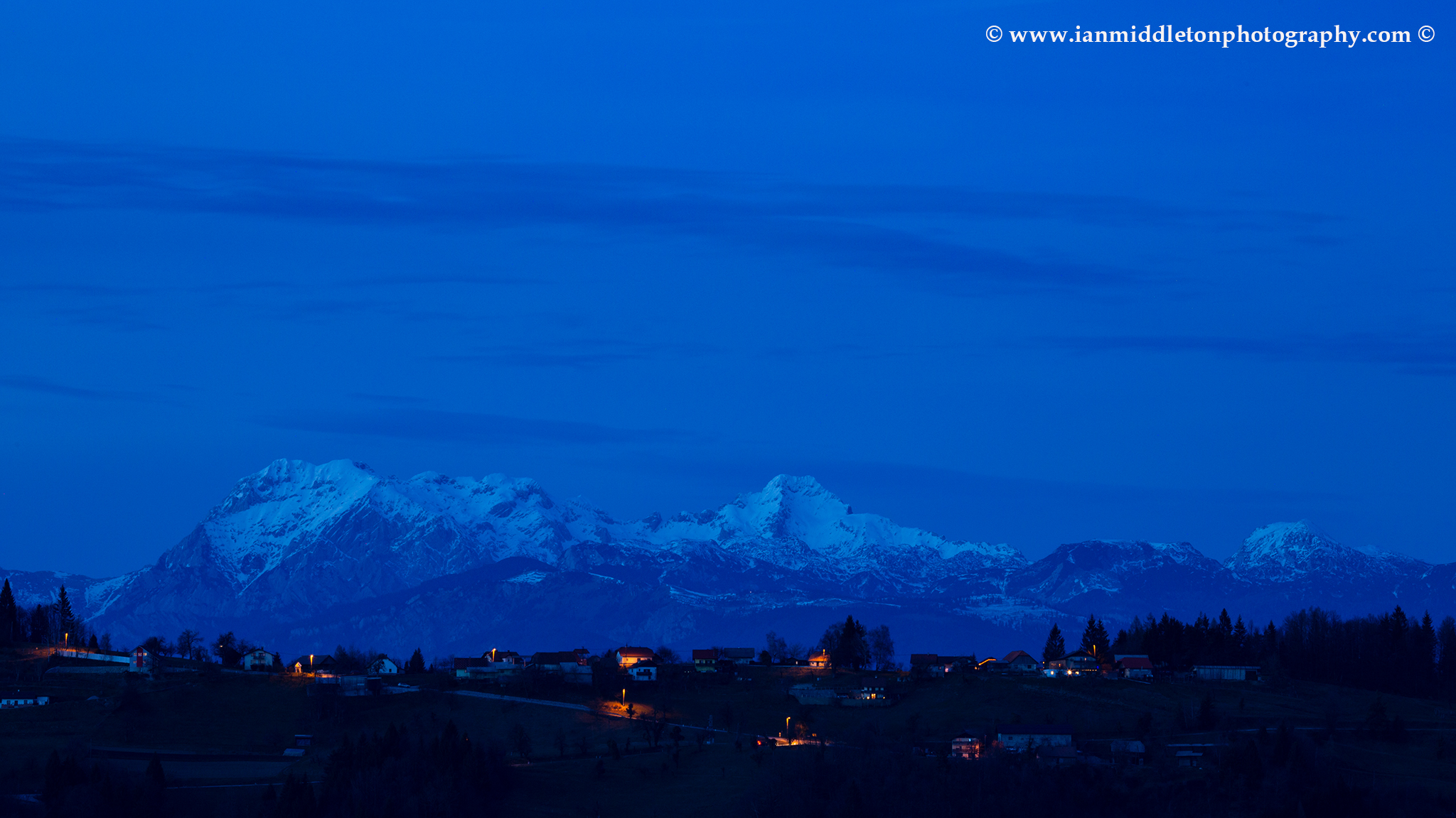 View across to the Kamnik Alps at dusk, seen from a hill in prezganje in the Jance hills to the east of Ljubljana, Slovenia