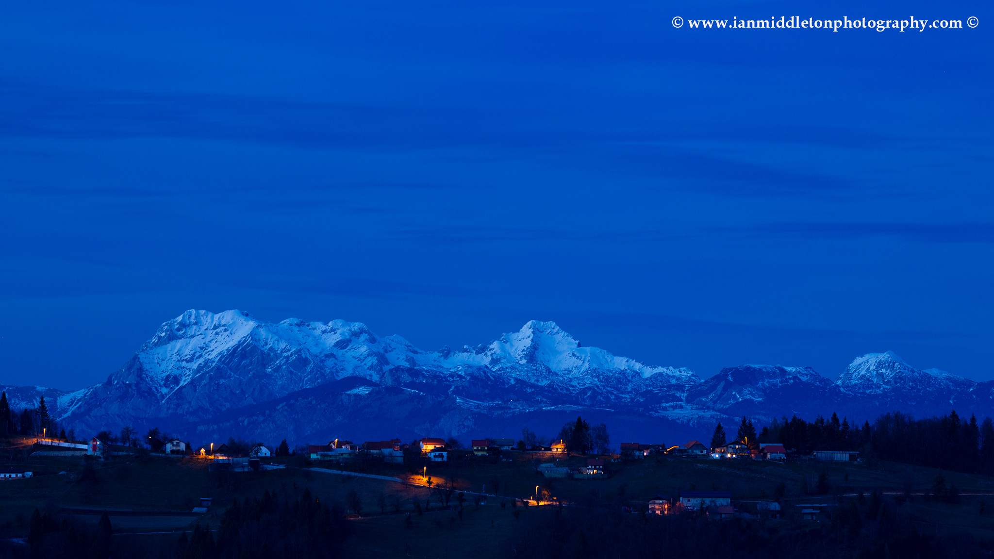 View across to the Kamnik Alps at dusk, seen from a hill in prezganje in the Jance hills to the east of Ljubljana, Slovenia