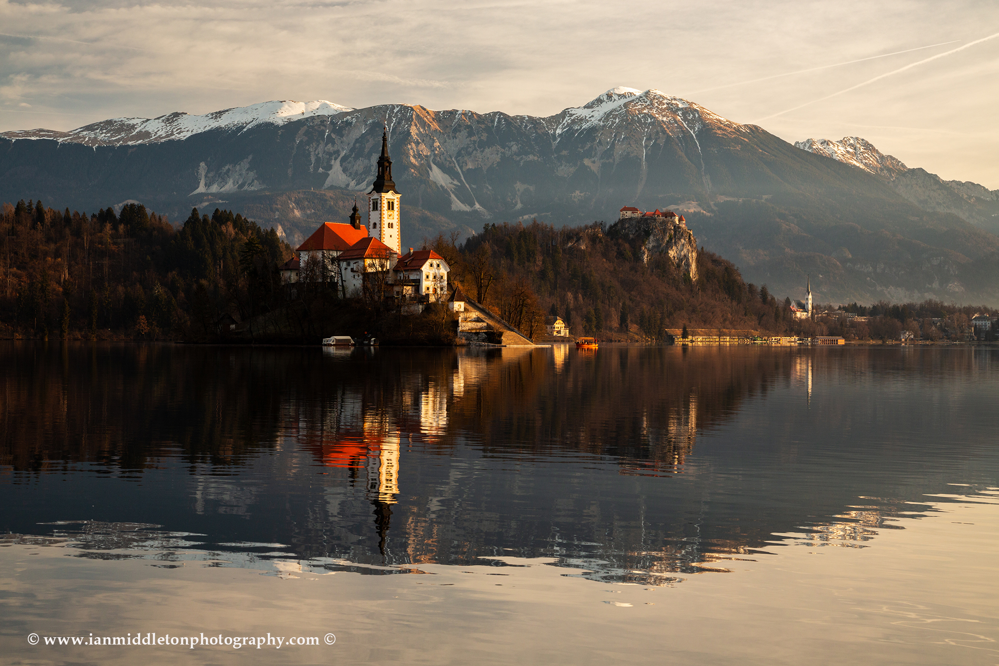Morning at Lake Bled and the island church of the assumption of Mary with the Karavanke mountains in the background, Slovenia.