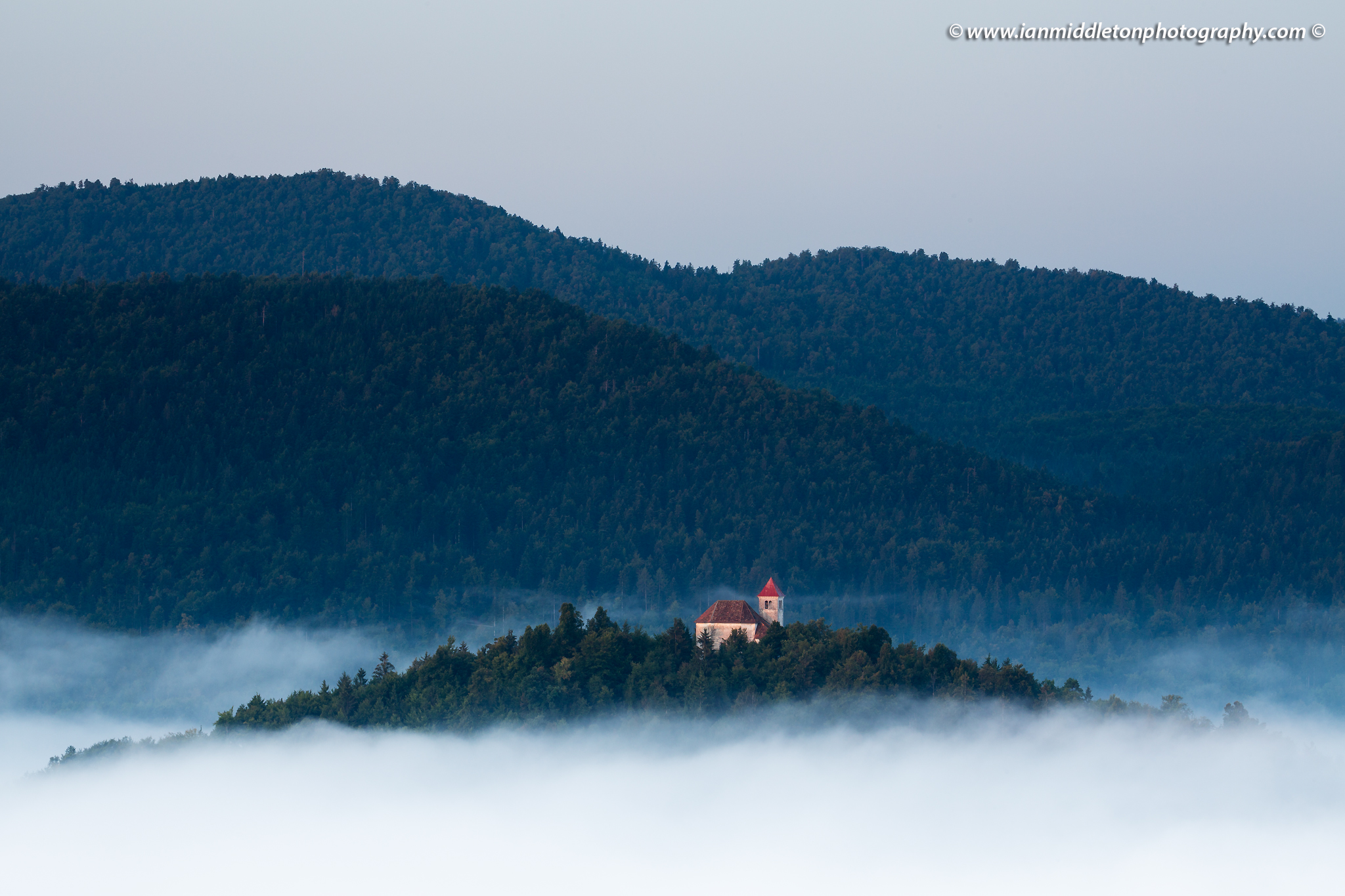 Morning light falling over the church of Sveti Josef (Saint Joseph), Slovenia. Seen from the church of Saint Anna (Sveta Ana). Sveta Ana is perched upon an exposed hill overlooking the Ljubljansko Barje (Ljubljana moors) near the village of Preserje.Morning light falling over the church of Sveti Josef (Saint Joseph), Slovenia. Seen from the church of Saint Anna (Sveta Ana). Sveta Ana is perched upon an exposed hill overlooking the Ljubljansko Barje (Ljubljana moors) near the village of Preserje.