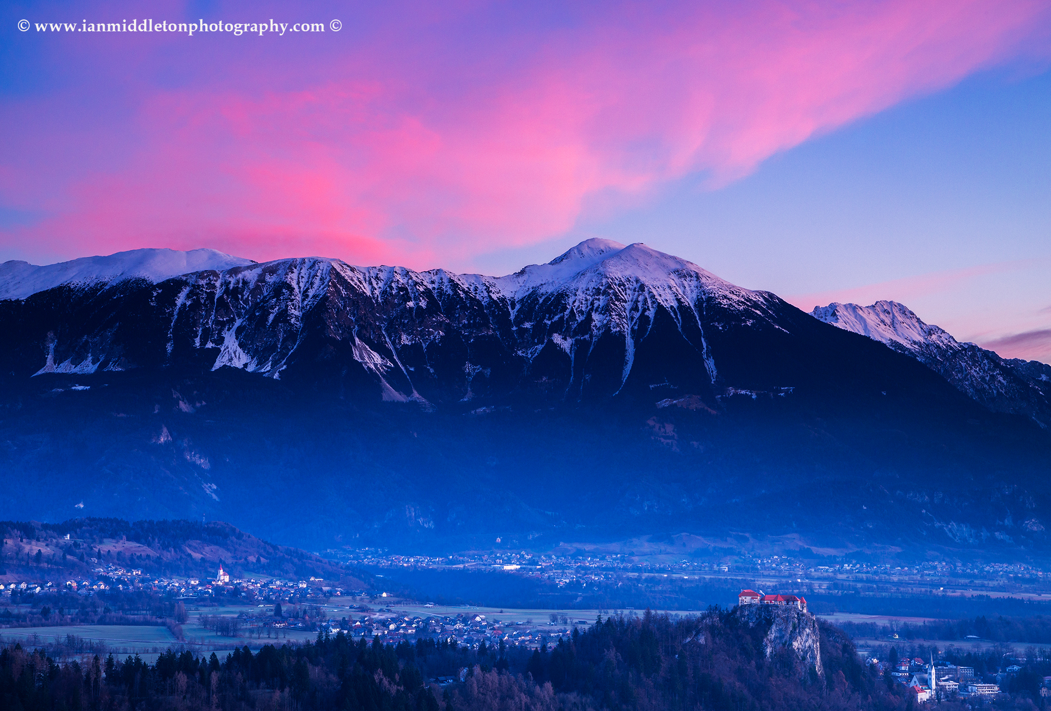 Sunrise over the clifftop castle and Mt Stol from Mala Osojnica at Lake Bled, Slovenia.