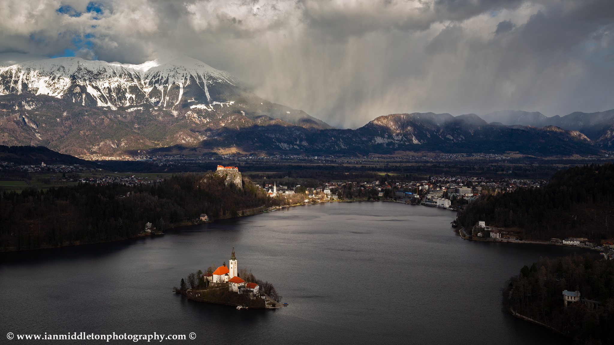 View across Lake Bled to the island church and clifftop castle from Mala Osojnica, Slovenia.