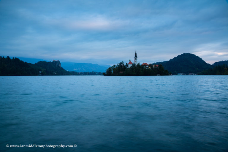 View across the beautiful Lake Bled, island church and hilltop castle at dusk, Slovenia.