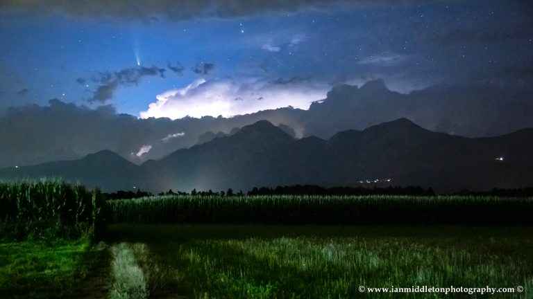 View of Neowise over the kamnik Alps with Storzic mountain to the right. Captured just as a flash of lightning lit up the clouds right over the mountains.