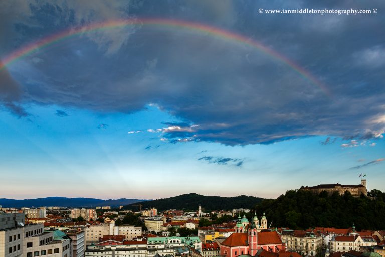 Ljubljana Castle and city centre with a rainbow over, Slovenia. Seen from Neboticnik terrace cafe.