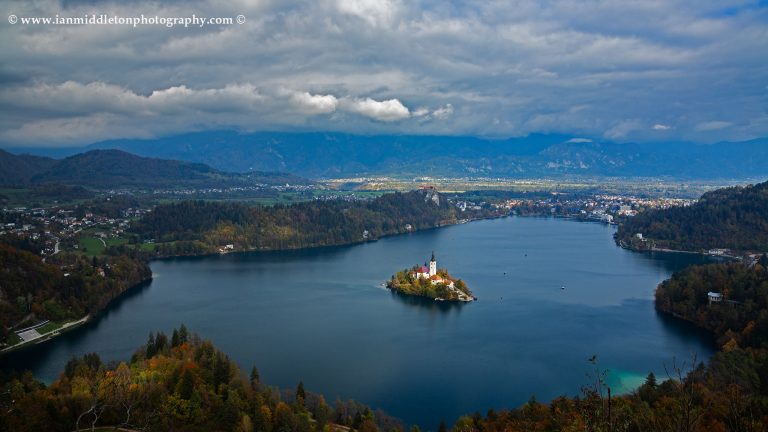 View across Lake Bled to the island church and clifftop castle from Mala Osojnica in autumn, Slovenia.