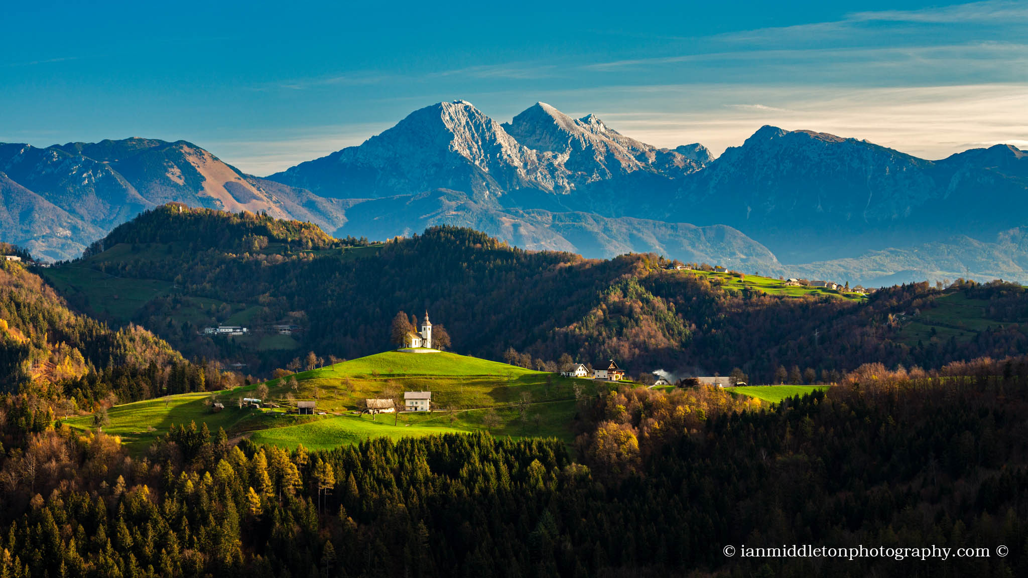 Autumn view from Rantovše hill across to Sveti Tomaz nad Praprotnim (church of Saint Thomas) and the Kamnik Alps, Slovenia.