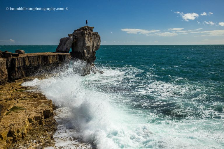 Waves crashing at sunset over Pulpit rock at Portland Bill, near Weymouth, Jurassic Coast, Dorset, England.