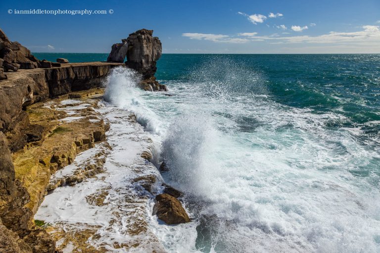 Waves crashing at sunset over Pulpit rock at Portland Bill, near Weymouth, Jurassic Coast, Dorset, England.