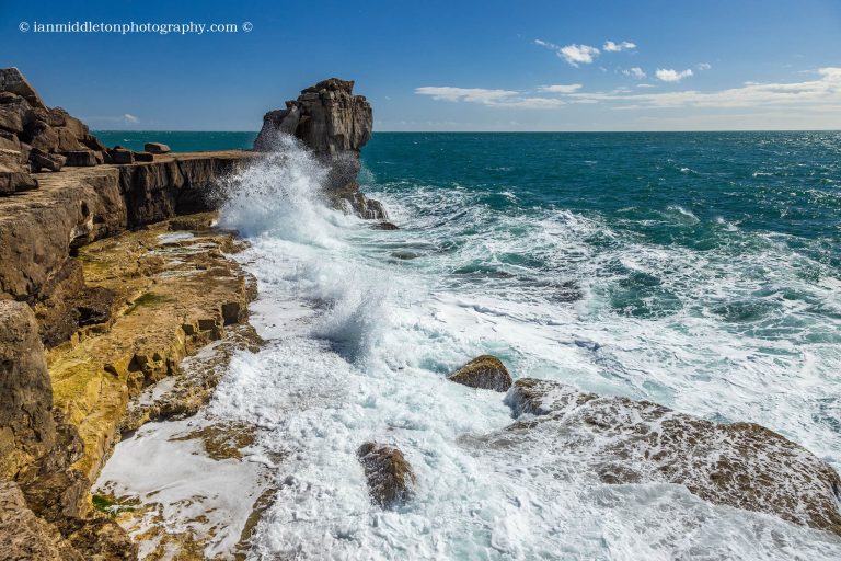 Waves crashing at sunset over Pulpit rock at Portland Bill, near Weymouth, Jurassic Coast, Dorset, England.