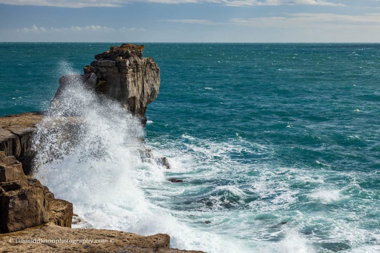 Waves crashing at sunset over Pulpit rock at Portland Bill, near Weymouth, Jurassic Coast, Dorset, England