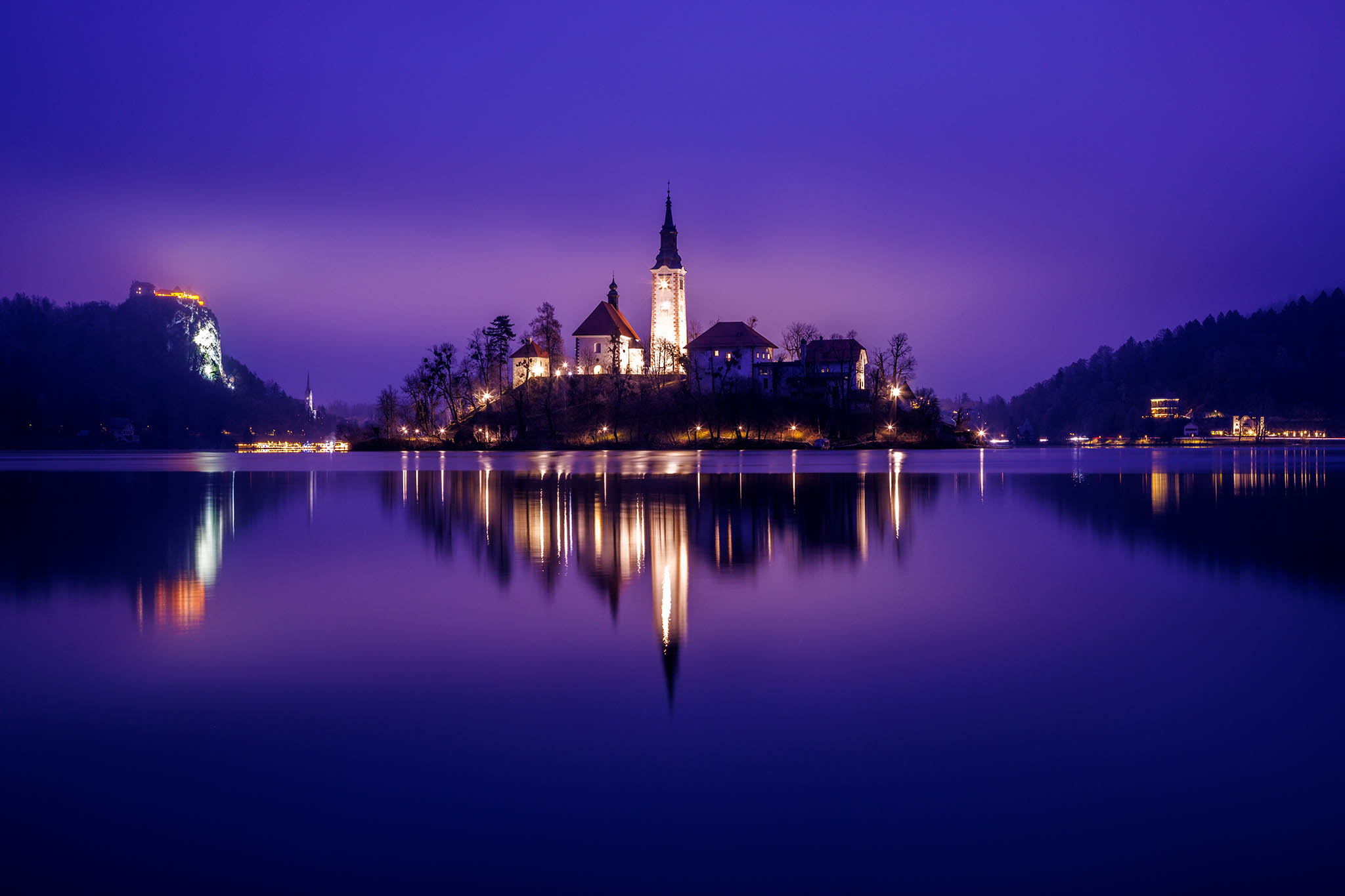 View across the beautiful Lake Bled, island church and hilltop castle at dusk, Slovenia.